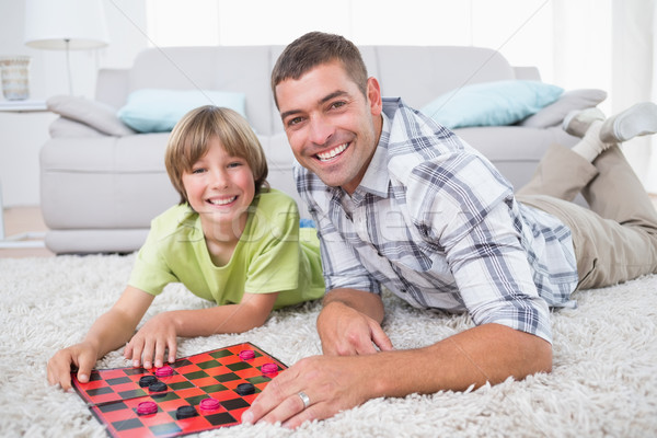 Father and son playing checker game on fur Stock photo © wavebreak_media