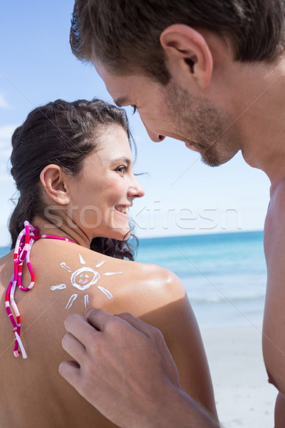 Handsome man putting sun tan lotion on his girlfriend Stock photo © wavebreak_media
