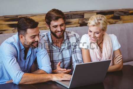 Foto stock: Sorridente · equipe · de · negócios · usando · laptop · café · escritório · feliz