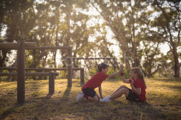 Kids giving high five to each other while exercising during obstacle course Stock photo © wavebreak_media