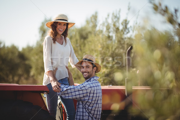 Portrait of happy man holding girlfriend standing on tractor Stock photo © wavebreak_media