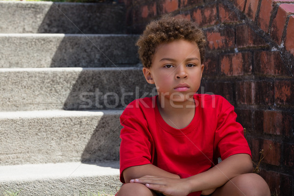 Upset boy sitting on staircase in the boot camp on a sunny day Stock photo © wavebreak_media