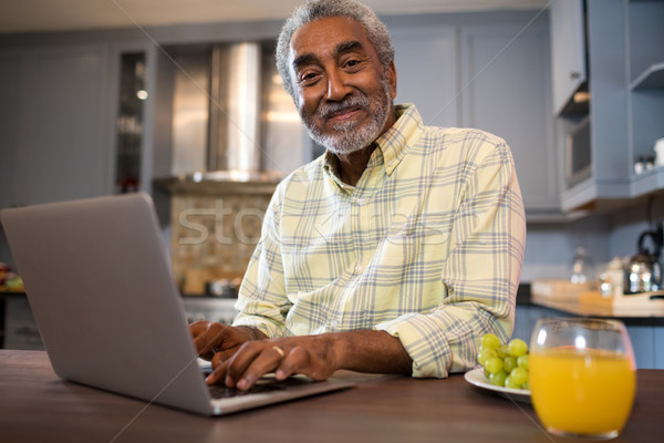 Ritratto senior uomo utilizzando il computer portatile computer seduta Foto d'archivio © wavebreak_media