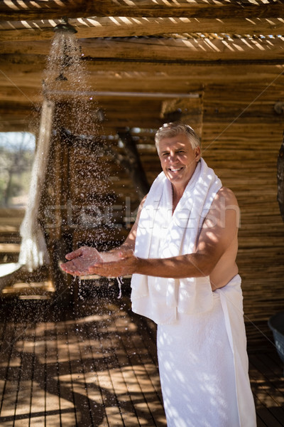 Man washing hands from shower in cottage during safari vacation Stock photo © wavebreak_media