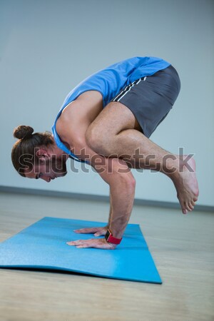 Stock photo: Yoga instructor practicing garland pose in club