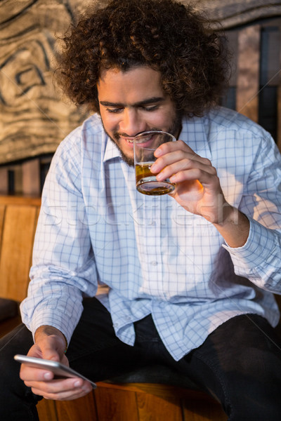 Man using mobile phone while having whisky Stock photo © wavebreak_media