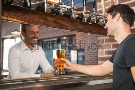 Two men toasting a glass of beer Stock photo © wavebreak_media