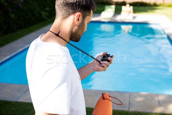 Lifeguard holding stopwatch at poolside Stock photo © wavebreak_media