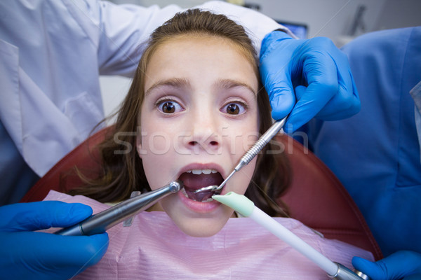 Dentists examining a young patient with tools Stock photo © wavebreak_media