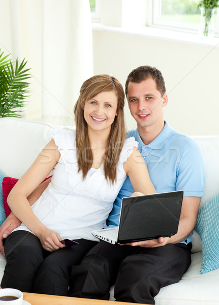 Enthusiastic couple using laptop smiling at the camera Stock photo © wavebreak_media