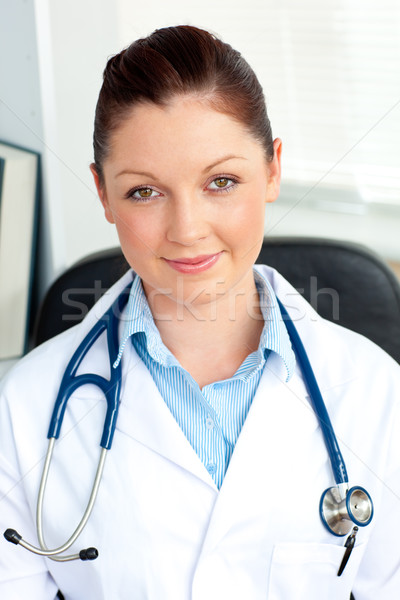 Stock photo: Self-assured female doctor smiling at the camera sitting in her practice