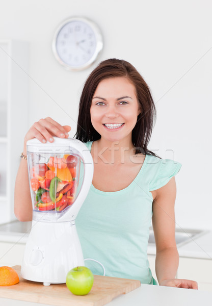 Charming woman posing with a blender in her kitchen Stock photo © wavebreak_media