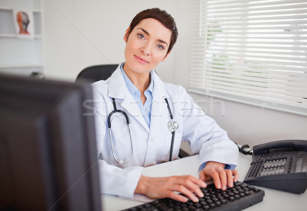 Sevimli kadın doktor yazarak bilgisayar ofis Stok fotoğraf © wavebreak_media