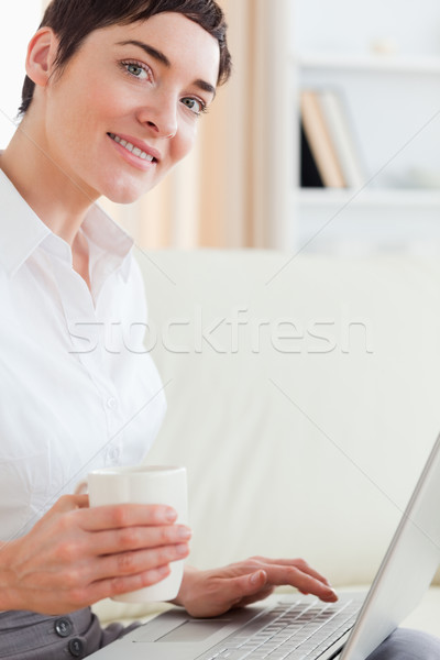 Cute donna Cup laptop soggiorno sorriso Foto d'archivio © wavebreak_media