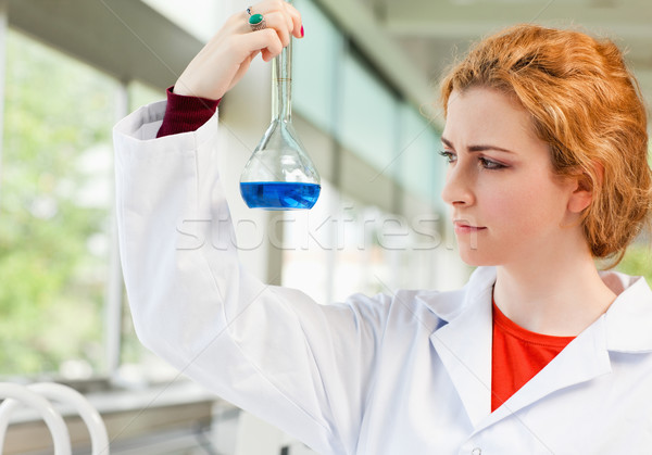 Cute scientist holding a blue liquid in a flask Stock photo © wavebreak_media