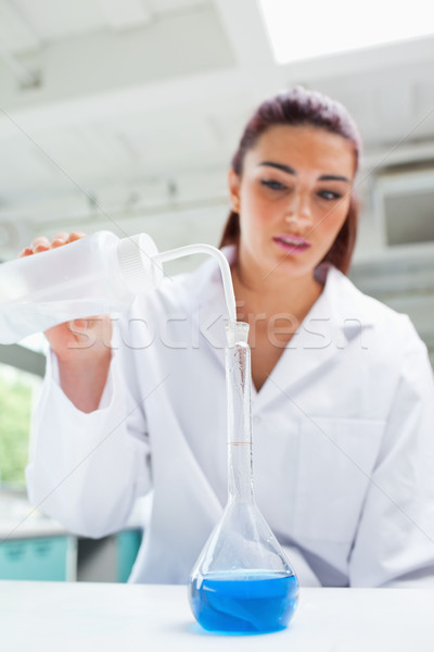 Portrait of a beautiful scientist pouring liquid in a flask Stock photo © wavebreak_media