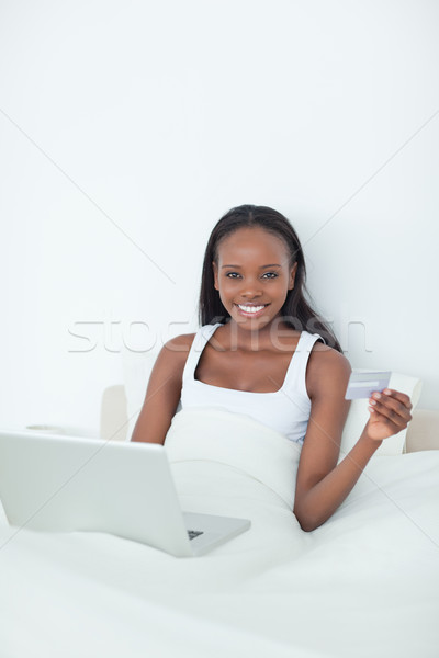 Portrait of a young woman purchasing online in her bedroom Stock photo © wavebreak_media