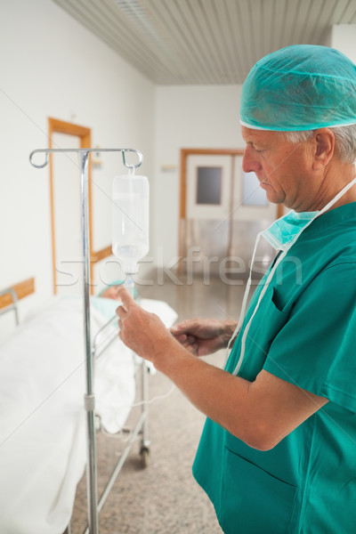 Surgeon measuring an intravenous drip in hospital corridor Stock photo © wavebreak_media