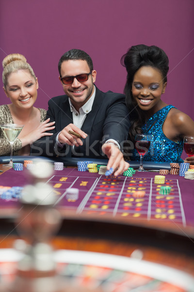 Man wearing sun glasses with women at roulette Stock photo © wavebreak_media