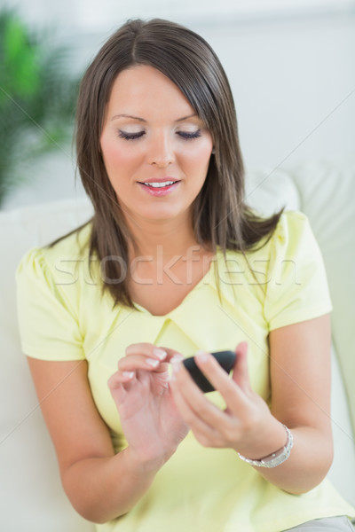 smiling woman touching her smartphone in the living room Stock photo © wavebreak_media