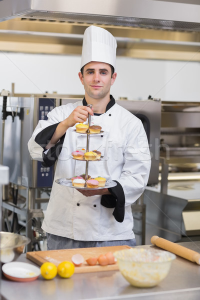 Pastry chef holding tiered cake tray in kitchen  Stock photo © wavebreak_media