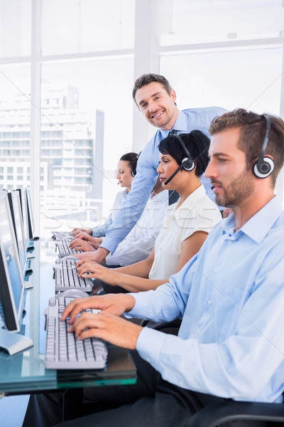 Stock photo: Manager and executives with headsets using computers