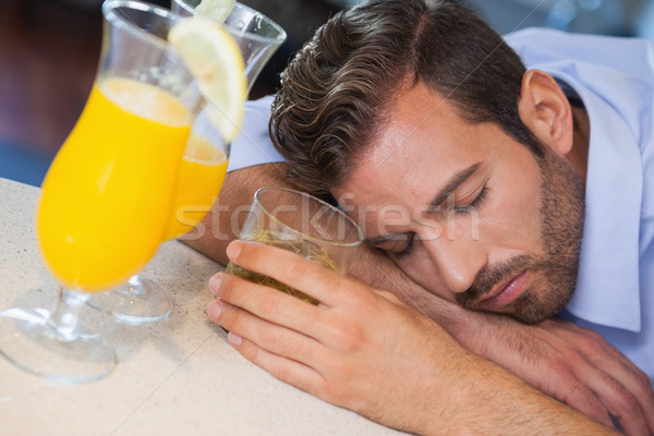 Drunk businessman sleeping on bar beside cocktail Stock photo © wavebreak_media