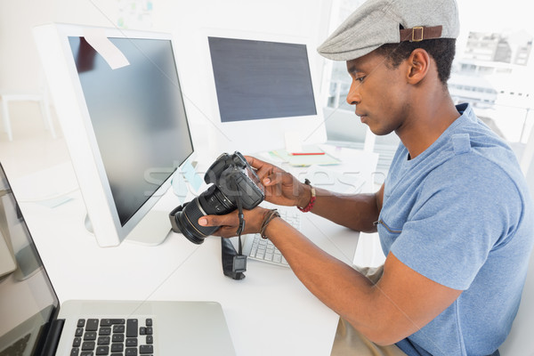 Fotografia redaktor patrząc aparat cyfrowy biuro widok z boku Zdjęcia stock © wavebreak_media