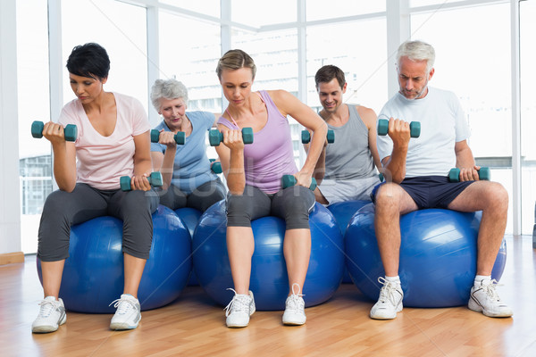 Fitness class with dumbbells sitting on exercise balls Stock photo © wavebreak_media
