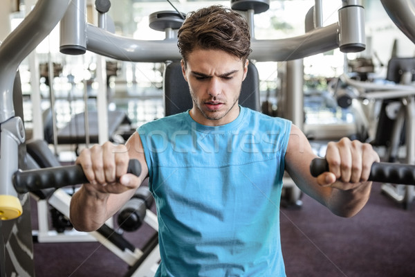 Focused man using weights machine for arms Stock photo © wavebreak_media