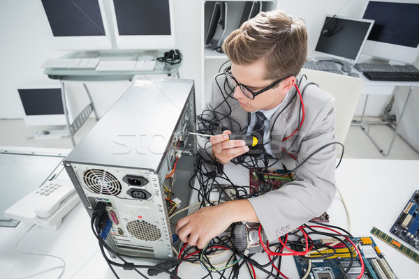 Computer engineer working on broken console with screwdriver Stock photo © wavebreak_media