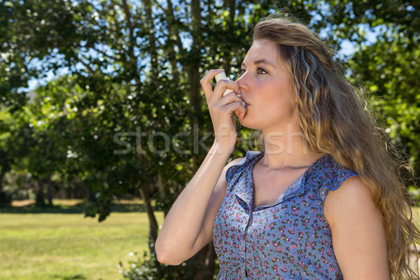 Stock photo: Pretty blonde using her inhaler