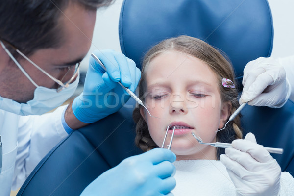 Dentist with assistant examining girls teeth Stock photo © wavebreak_media