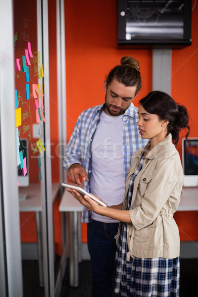 Stock photo: Male and female executives discussing over digital tablet