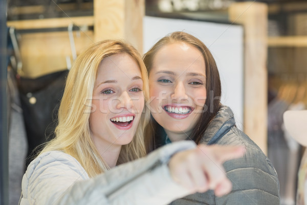 Two smiling female friends pointing away Stock photo © wavebreak_media