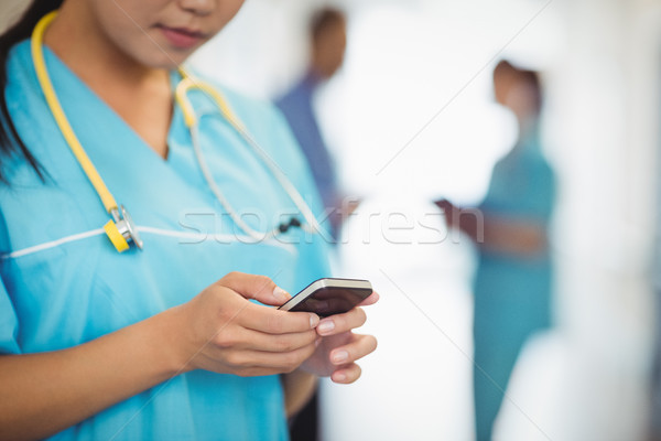 Középső rész nővér sms üzenetküldés mobiltelefon kórház internet Stock fotó © wavebreak_media