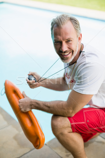Portrait of smiling swim coach holding stop watch and inflatable tube Stock photo © wavebreak_media