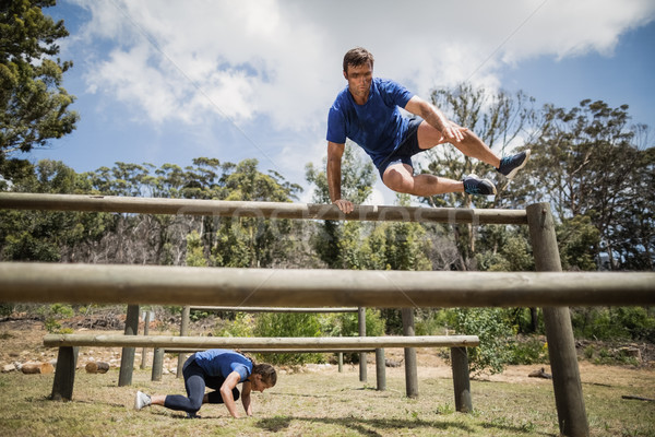 Man and woman jumping over the hurdles during obstacle course Stock photo © wavebreak_media
