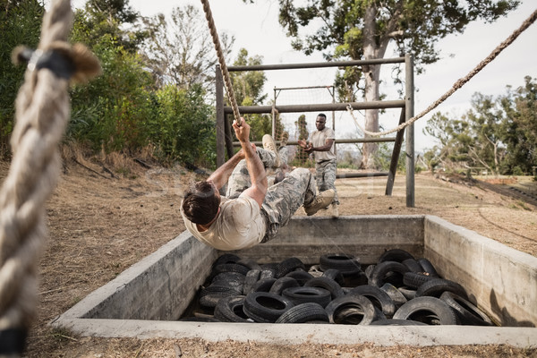 Young military soldiers practicing rope climbing during obstacle course Stock photo © wavebreak_media