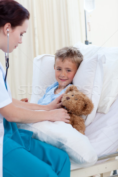 Female doctor listening to a child chest and a teddy bear Stock photo © wavebreak_media