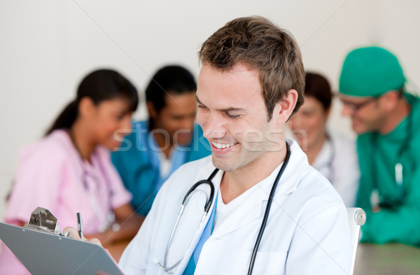 Jungen männlichen Arzt lächelnd Kamera Team Lächeln Stock foto © wavebreak_media