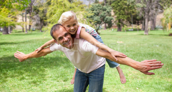 Stock photo: Adorable little girl having fun with her father in a park