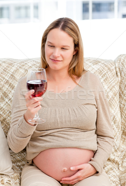 Femeie gravida uita sticlă vin rosu şedinţei canapea Imagine de stoc © wavebreak_media