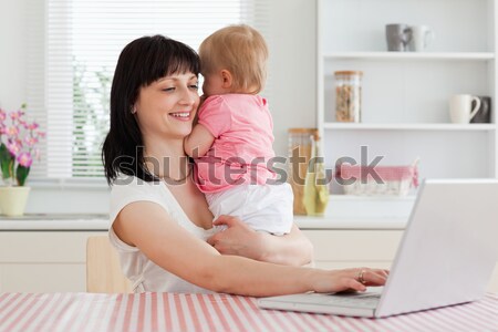 Anziehend Brünette Frau Telefon halten Baby Arme Stock foto © wavebreak_media