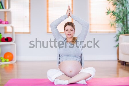 Portrait of a cheerful woman squatting on a weighing machine Stock photo © wavebreak_media