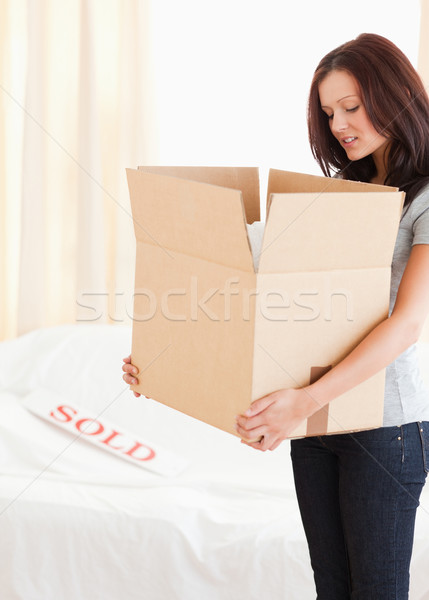 A standing woman is holding a cardboard and looking into it Stock photo © wavebreak_media