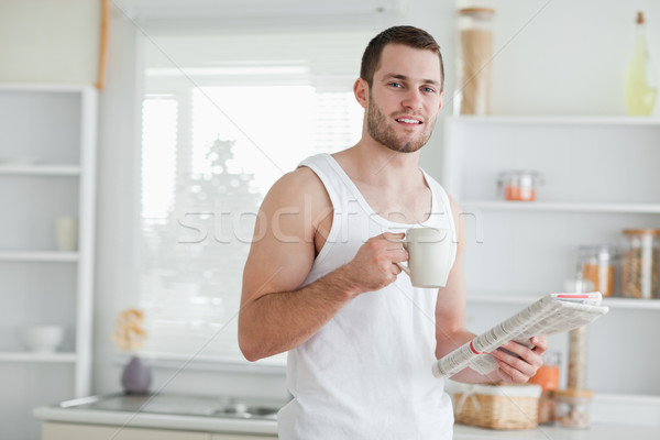 Delighted man drinking tea while reading the news in his kitchen Stock photo © wavebreak_media