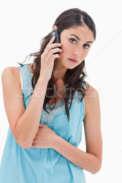 Stock photo: Portrait of a tired woman making a phone call against a white background