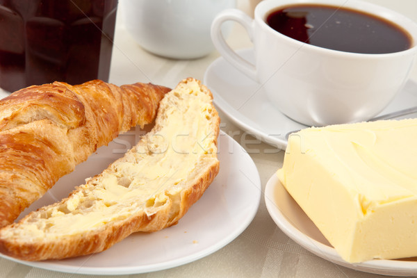 Breakfast with a croissant spread with butter indoors Stock photo © wavebreak_media