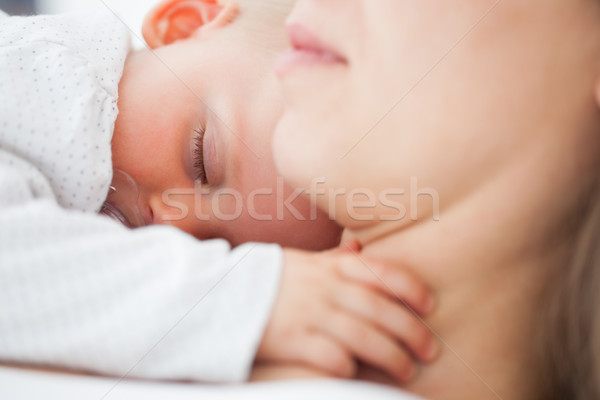 Cute baby sleeping on the chest of her mother indoors Stock photo © wavebreak_media